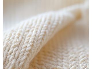 Mikroskopisk nærbilde som viser usynlig reparasjon av en strikkegenser